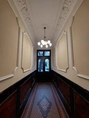 an empty hallway with a door and a chandelier at Bukoleon Apartment in Belgrade