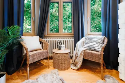 a room with two chairs and a radiator and windows at Soul House 110m2 with Balcony & Foosball Old Town in Belgrade