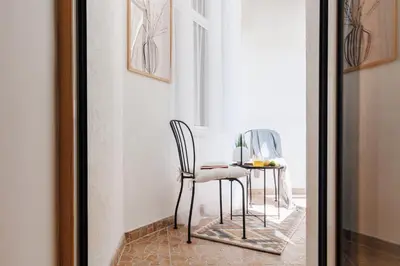 a table and chairs in a room with a window at Soul House 110m2 with Balcony & Foosball Old Town in Belgrade