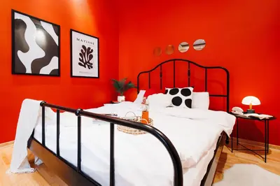 a bedroom with red walls and a black and white bed at Soul House 110m2 with Balcony & Foosball Old Town in Belgrade