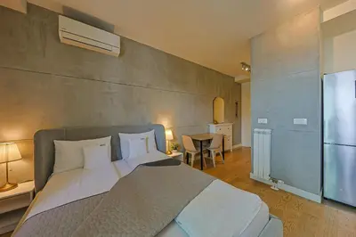 a bedroom with a large bed and a kitchen at ZIGZAG Belgrade Waterfront Metropoliten in Belgrade