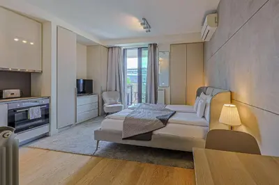 a bedroom with a bed and a living room at ZIGZAG Belgrade Waterfront Metropoliten in Belgrade