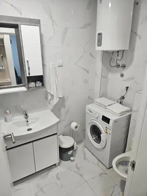 a white bathroom with a washing machine and a sink at Miss LuX in Mladenovac