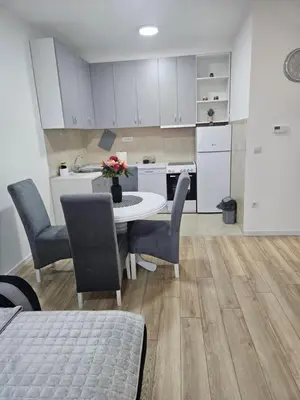 a kitchen and dining room with a table and chairs at Miss LuX in Mladenovac