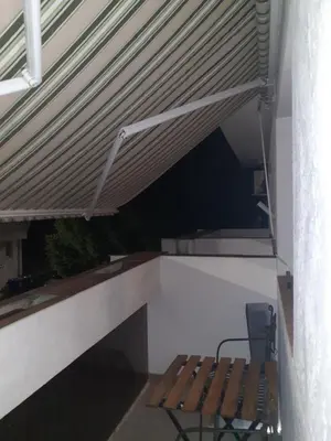 a bench sitting under awning on a patio at Batajnica centar in Belgrade