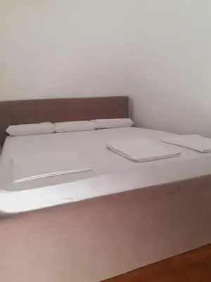 a bed with white sheets and pillows on it at Batajnica centar in Belgrade