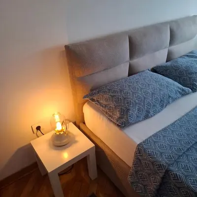 a bed with a candle on a table next to it at BelMont Vračar in Belgrade