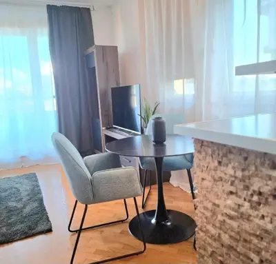 a living room with a table and chairs and a laptop at BelMont Vračar in Belgrade