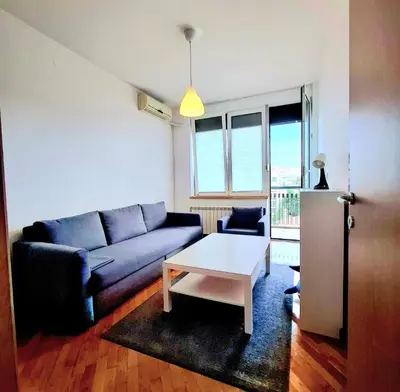 a living room with a blue couch and a coffee table at BelMont Vračar in Belgrade