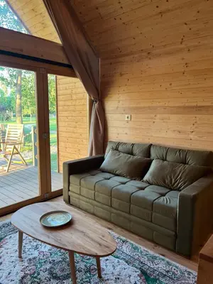 a living room with a couch and a table at Ritopia Glamping in Kovilj
