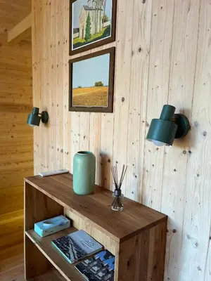 a room with a wooden wall with a shelf with wine bottles at Ritopia Glamping in Kovilj