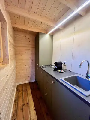 a kitchen with a sink and a counter top at Ritopia Glamping in Kovilj