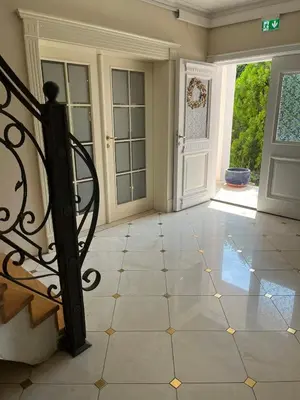 an empty room with a door and a tiled floor at Vila Monika in Belgrade