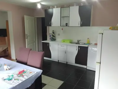 a kitchen with white cabinets and a sink and a table at Zemun in Belgrade