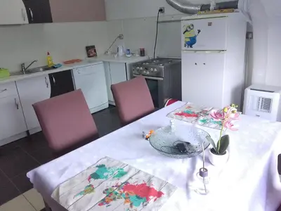 a kitchen with a table and two pink chairs at Zemun in Belgrade