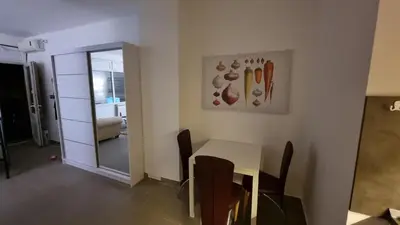 a dining room with a table and chairs and a mirror at Stan na dan Beoshoping in Belgrade