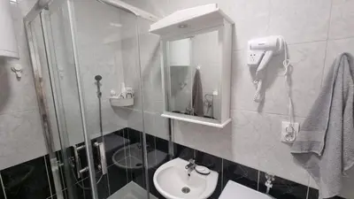 a bathroom with a shower and a sink and a phone at Stan na dan Beoshoping in Belgrade