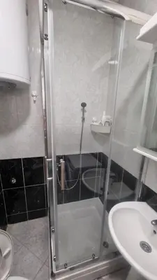 a shower with a glass door next to a sink at Stan na dan Beoshoping in Belgrade
