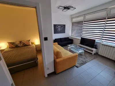 a living room with a bed and a couch at Stan na dan Beoshoping in Belgrade