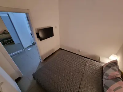 a small bedroom with a bed and a television at Stan na dan Beoshoping in Belgrade