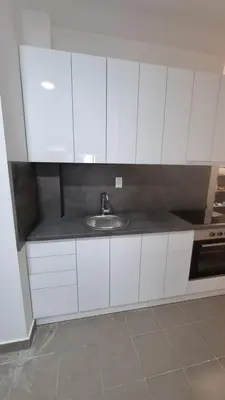 a kitchen with white cabinets and a sink at Stan na dan Beoshoping in Belgrade