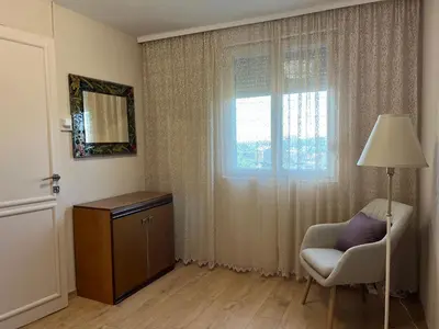 a living room with a chair and a window at R&R apartment Medak 3 in Belgrade