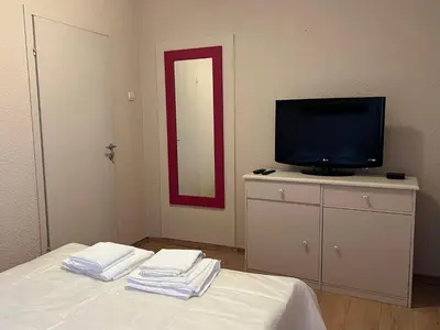 a room with a tv and a bed with towels at R&R apartment Medak 3 in Belgrade