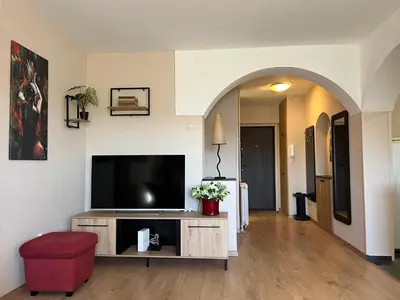 a living room with a flat screen tv and a red stool at R&R apartment Medak 3 in Belgrade