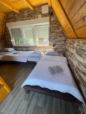 a bedroom with two beds in a log cabin at Kuća sa Pogledom in Sremski Karlovci
