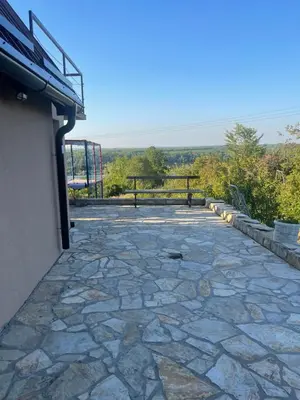 a stone patio with a bench in the background at Kuća sa Pogledom in Sremski Karlovci