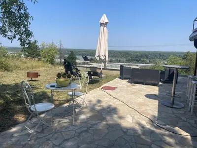 a patio with a table and chairs and an umbrella at Kuća sa Pogledom in Sremski Karlovci