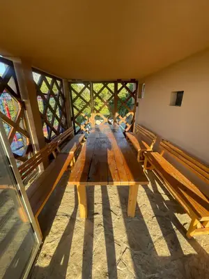 a long wooden table in a room with benches at Kuća sa Pogledom in Sremski Karlovci
