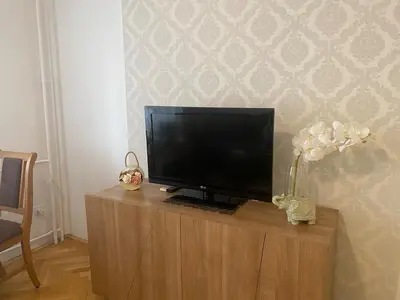 a flat screen tv sitting on top of a wooden cabinet at Cozy apartment - Downtown in Belgrade