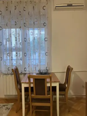 a dining room with a table and chairs and a window at Cozy apartment - Downtown in Belgrade
