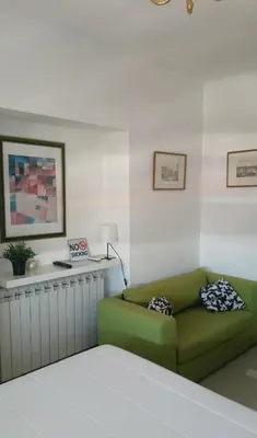 a living room with a green couch in a room at Ogi apartment Beograd in Belgrade