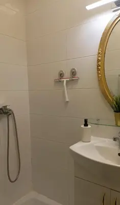 a white bathroom with a sink and a mirror at Ogi apartment Beograd in Belgrade