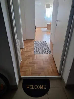 a hallway with a door and a welcome mat on the floor at Amar6 in Novi Beograd