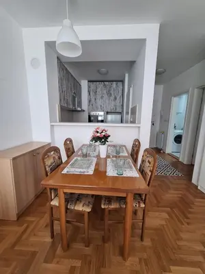 a dining room with a wooden table and chairs at Amar6 in Novi Beograd