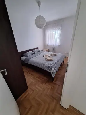 a bedroom with a bed and a wooden floor at Amar6 in Novi Beograd