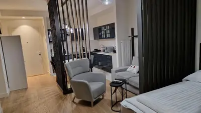 a bedroom with a bed and two chairs and a table at Sava Lux in Sajmište