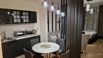 a room with a table and a kitchen with a table and chairs at Sava Lux in Sajmište
