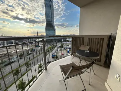 a balcony with a table and chair and a view of a city at BW AQUA Joi Lux 2 Apartment in Belgrade