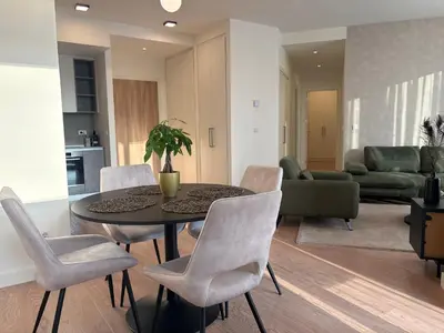 a living room with a dining room table and chairs at BW AQUA Joi Lux 2 Apartment in Belgrade