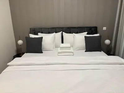 a large white bed with black and white pillows at BW AQUA Joi Lux 2 Apartment in Belgrade