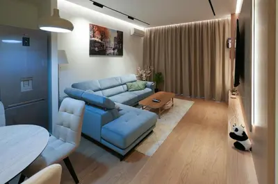 a living room with a blue couch and a table at Scala Reale in Sajmište
