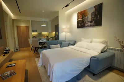 a bedroom with a large bed and a living room at Scala Reale in Sajmište