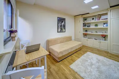 a living room with a couch and a table with a laptop at Oasis Moonze in Zemun