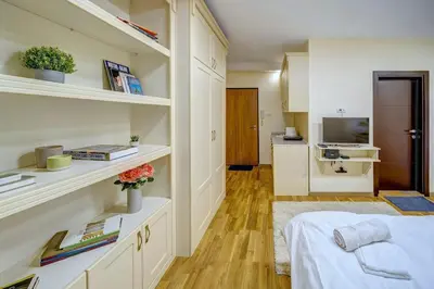 a bedroom with a bed and a desk with books at Oasis Moonze in Zemun