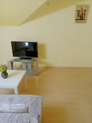 a living room with a television and a white table at Stan Na Dan - Mladenovac in Mladenovac