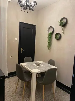 a dining room with a table and chairs and a black door at Okapi stays in Belgrade